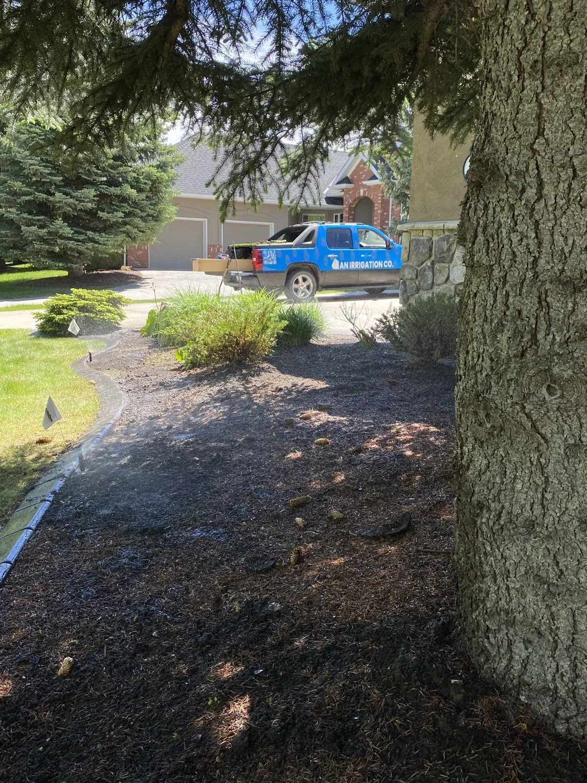 Fresh-edged mulch beds out front, the truck still in the drive